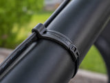 Close-up of a Flexroute rubber clamp routing a black cable smoothly along a UTV roll cage