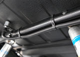 Flexroute rubber clamp keeping underbody tubing secure and vibration-free near vehicle suspension.