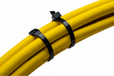 Two black Cobra low profile cable ties bundling a coil of thick yellow hoses tightly together.