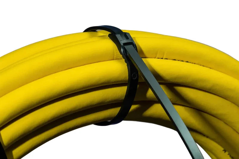 Close-up of wire cutters trimming the excess tail off a Cobra low profile zip tie secured around yellow tubing.