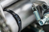 Cobra low profile zip tie fastening a black cable around a metallic engine reservoir and hydraulic lines