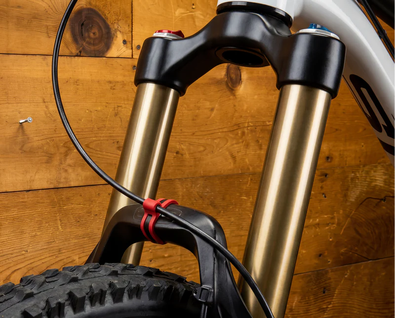 Flexroute line clamp securing a front hydraulic brake hose to a mountain bike suspension fork.