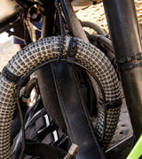 Flexroute rubber line clamp fastening a protective braided wire loom to a vehicle chassis.